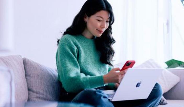 femme avec ordinateur et téléphone portable réalisant une transaction