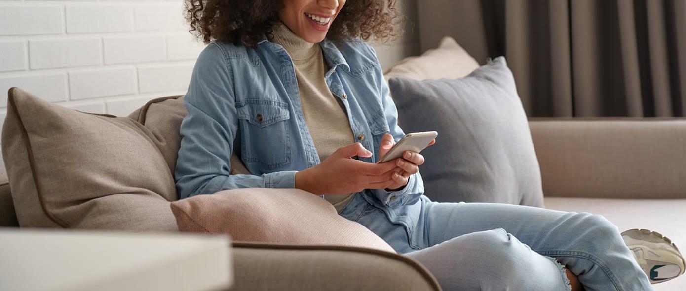 mobile banking jeune femme sur canapé 